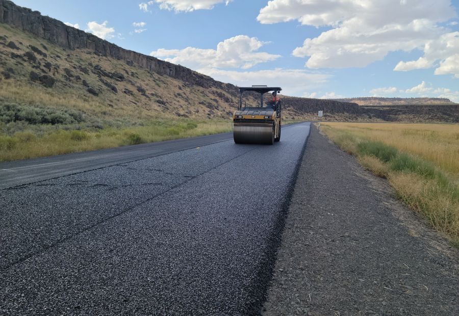 Double-drum roller compacting a fresh mat of asphalt on a driveway overlay